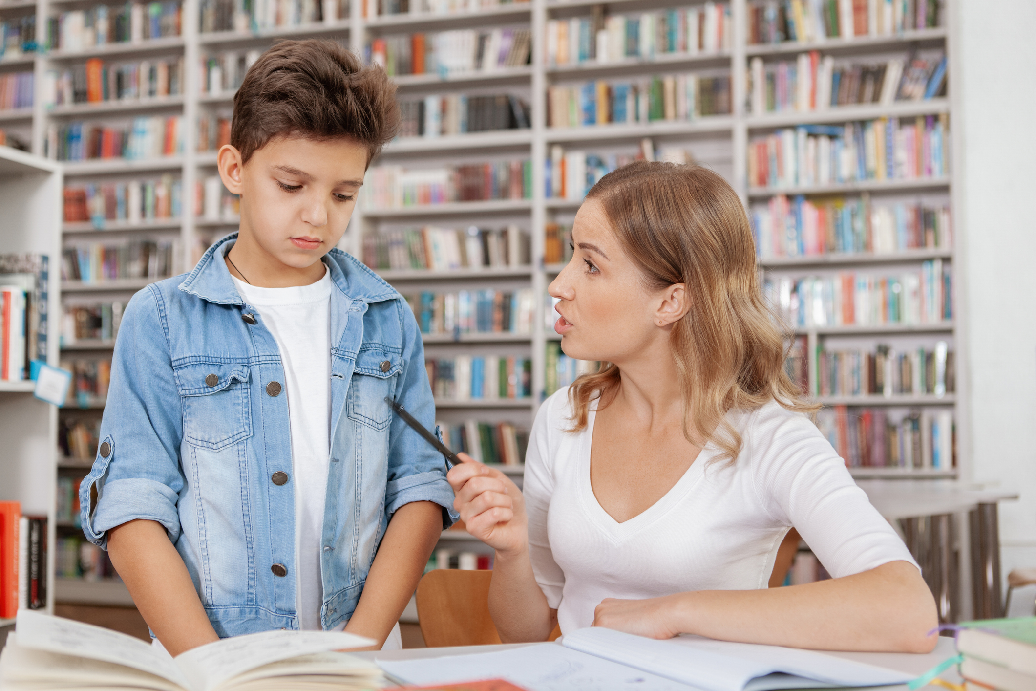 Cute young boy studying with his mom at the library